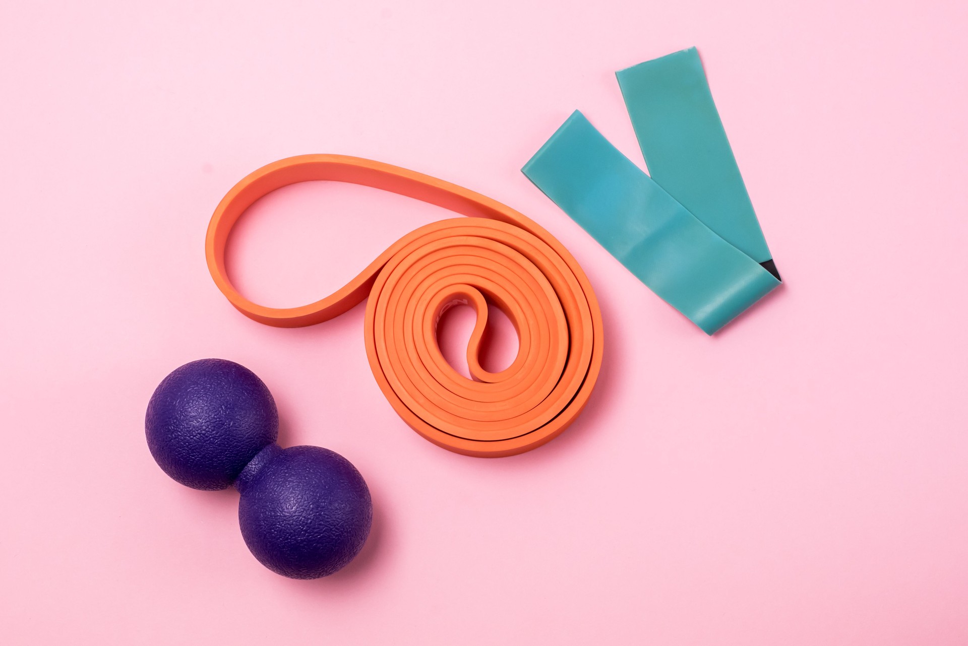 Fitness Bands and Rollers for Yoga Pilates or MFR Minimal Home Fitness Concept Top View Pink Background